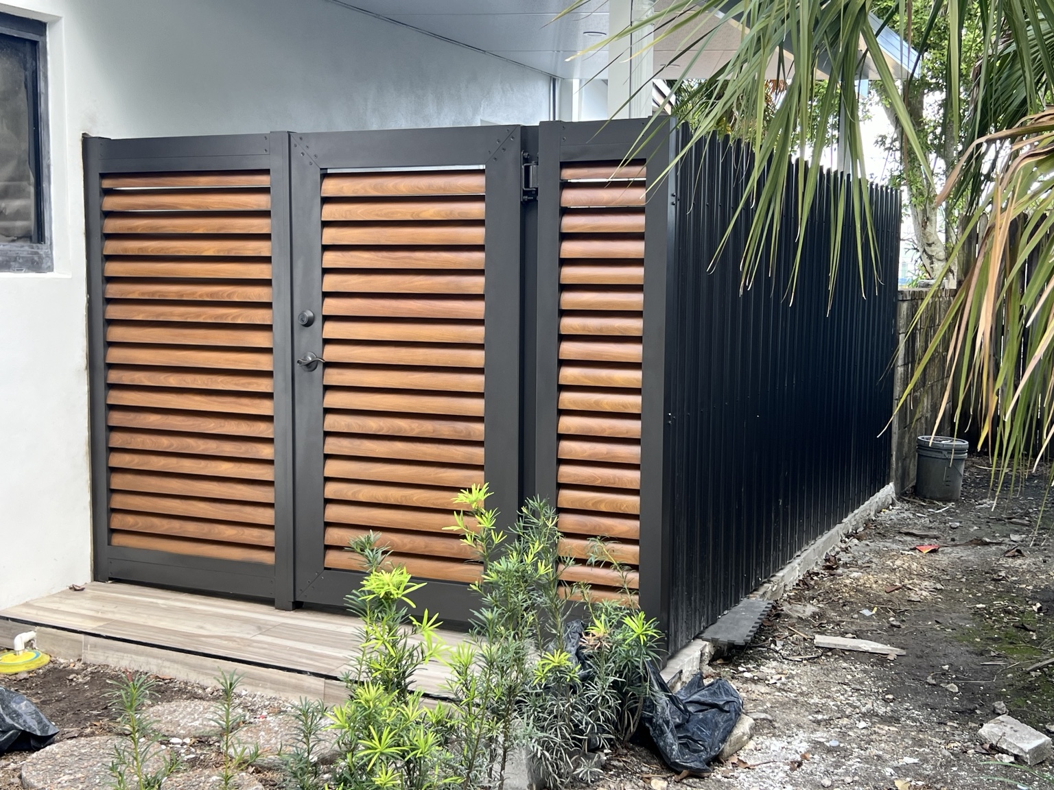 Black aluminum gate with horizontal wood-look louvers