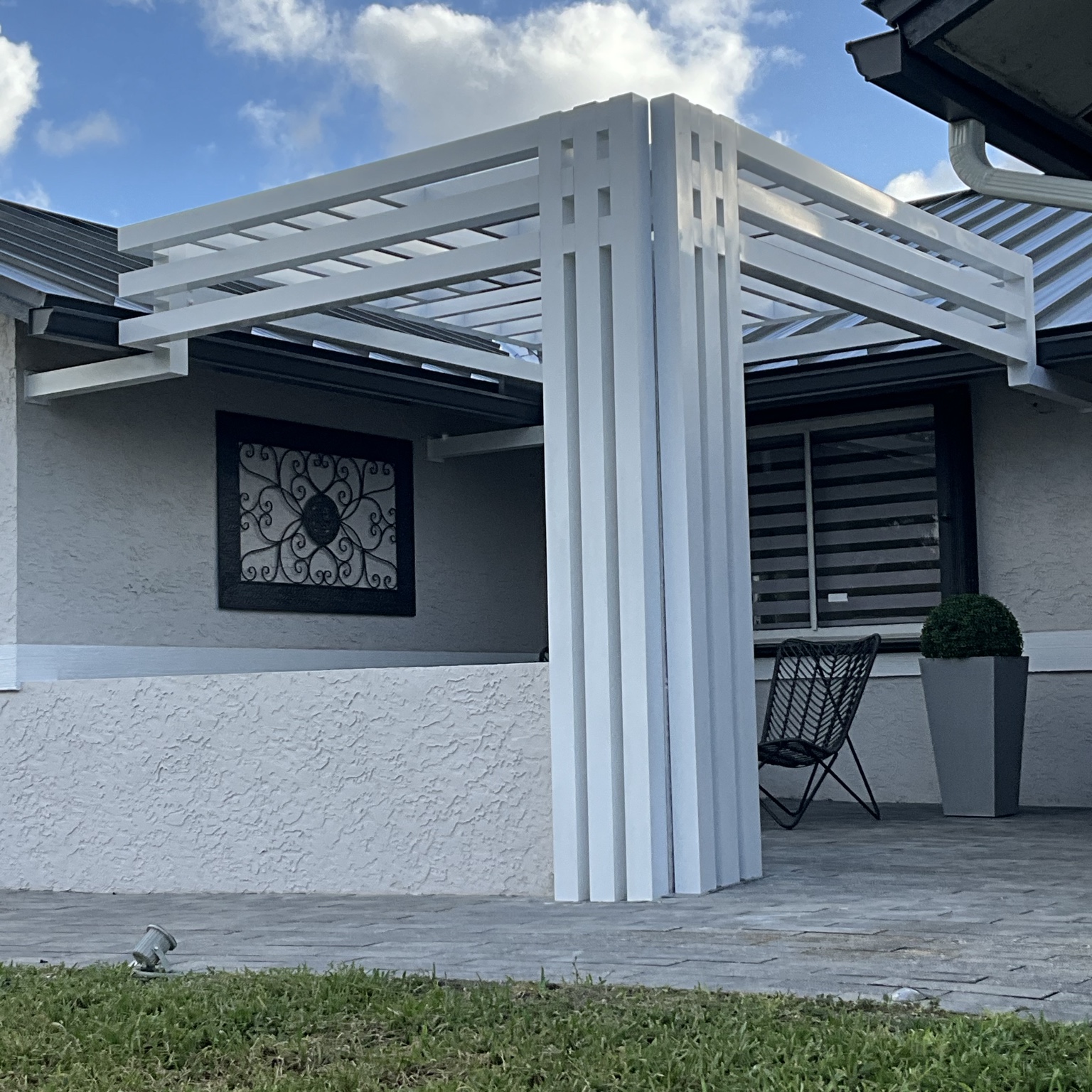 Completed custom white aluminum pergola connecting two sides of a patio