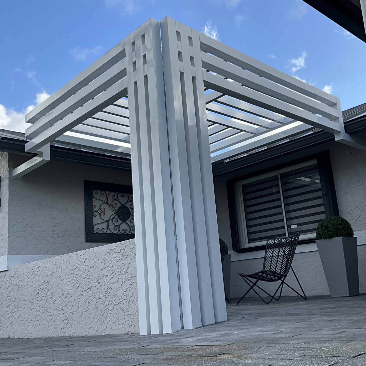Low-angle detail of the finished white aluminum pergola