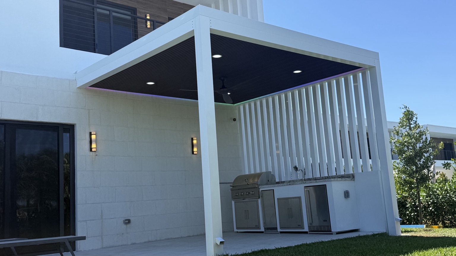 White custom aluminum pergola with integrated outdoor kitchen