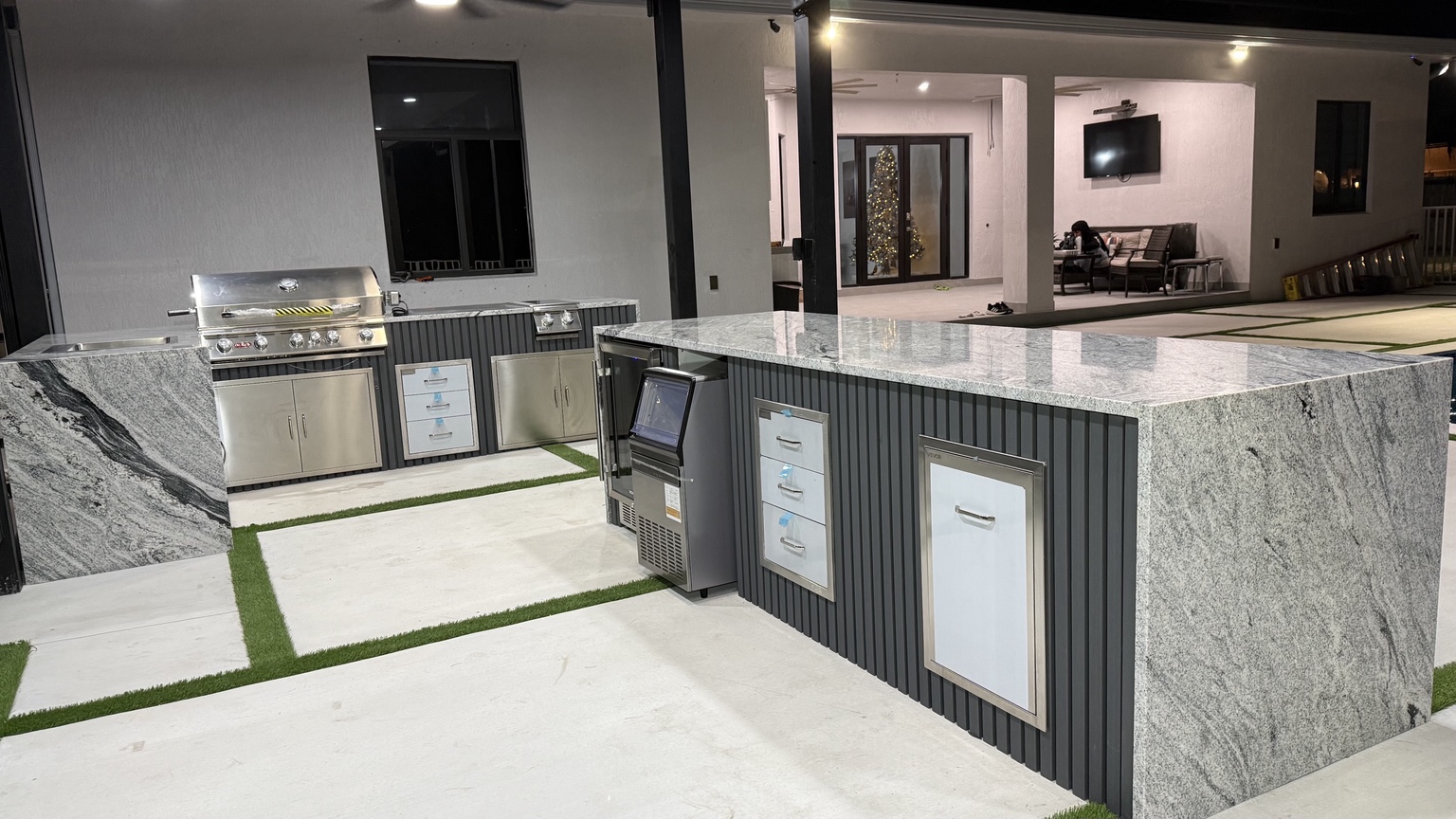 Custom gray outdoor kitchen with waterfall stone countertop