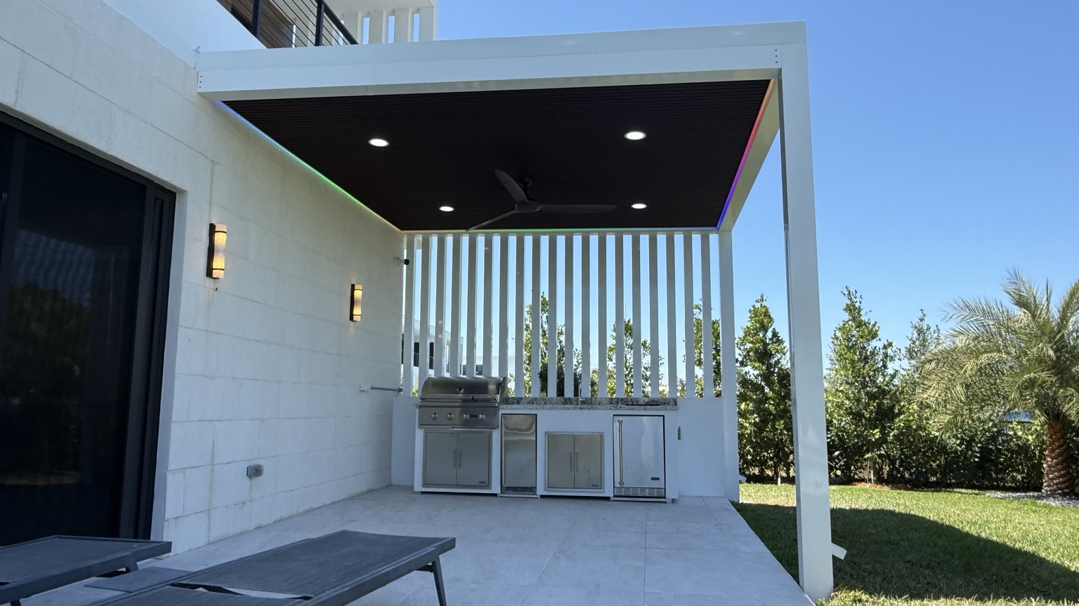 White aluminum pergola with dark wood-look ceiling