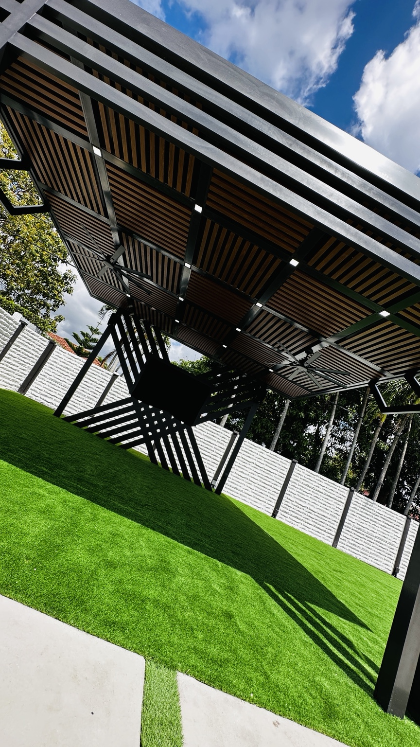 Close view of the custom wood-look slat roof, integrated lights, fans, and geometric aluminum structure