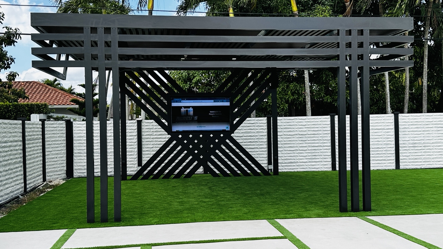 Custom black aluminum pergola with geometric privacy wall and wood-look slat roof